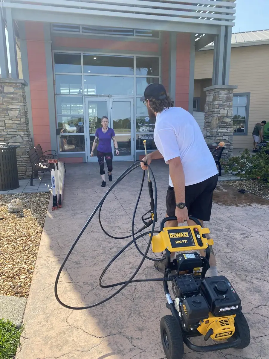 Joey from Orchid Cleaning Service pressure-washing a commercial entryway