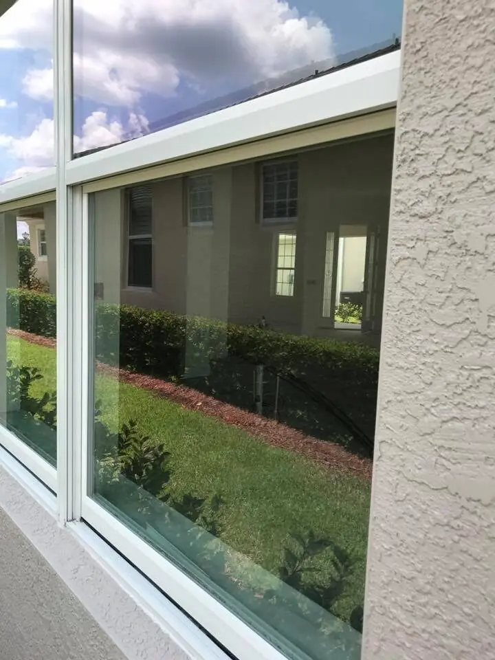 Crystal-clear residential window with sky and lawn reflection after Orchid cleaning